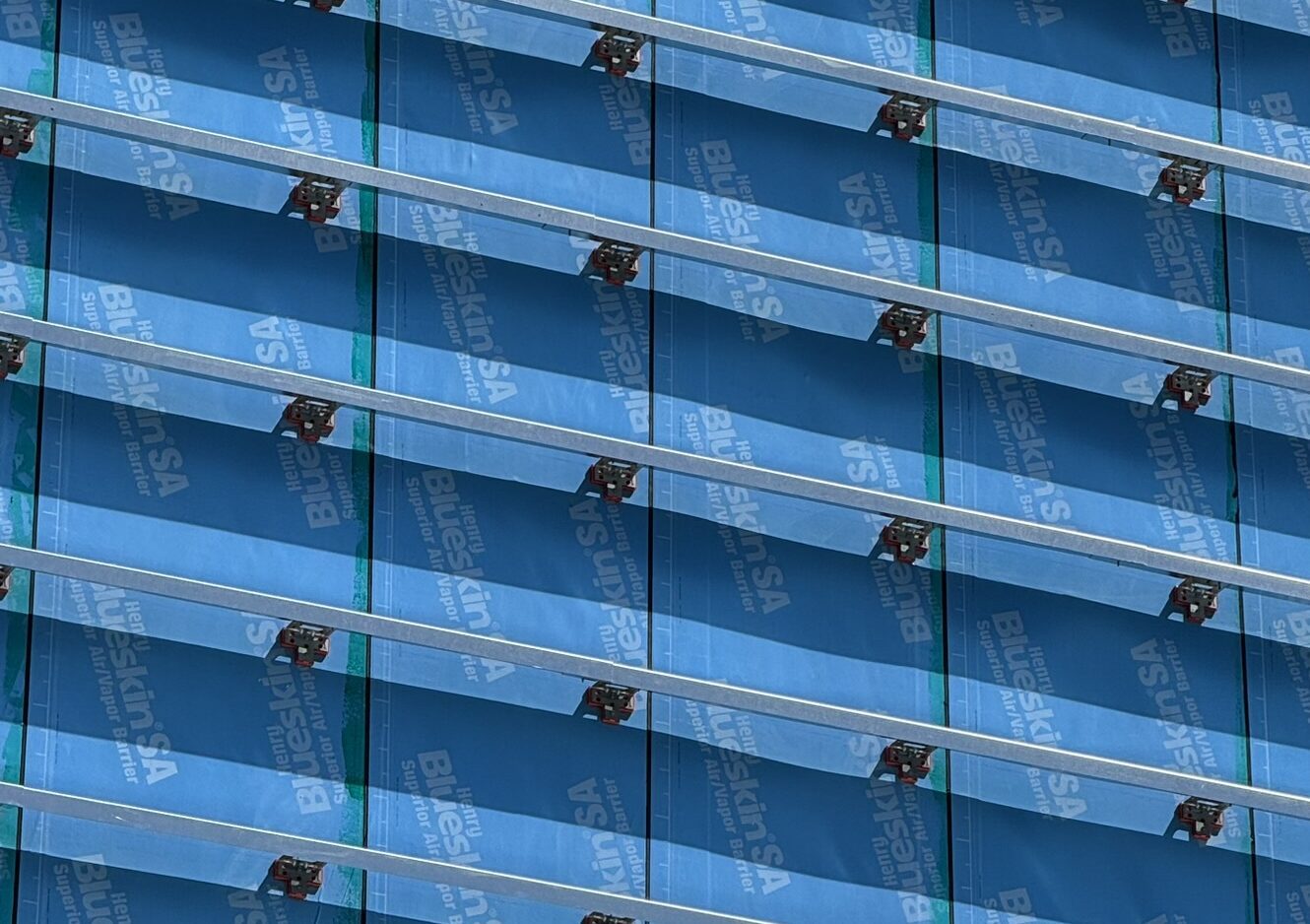 Close-up of TAC 2.1 thermal assembly clips mounted on a façade air/vapour barrier with horizontal rainscreen sub-framing